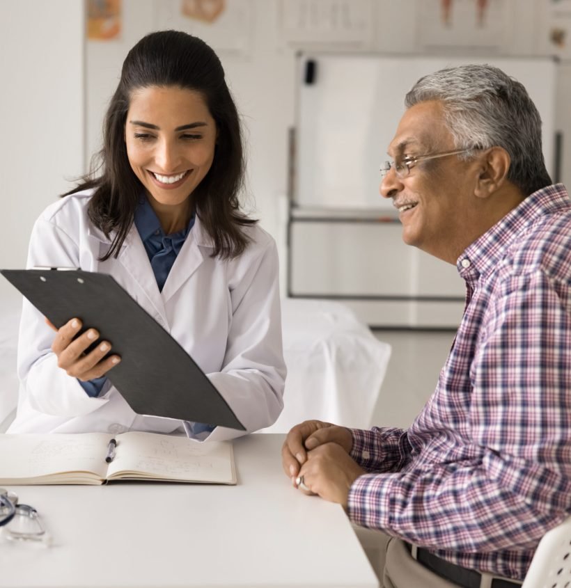 Cheerful young doctor woman showing medical report to elderly patient man, explaining healthcare examination results, prescription, treatment recommendation, giving consultation